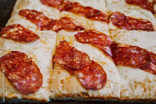 A sheet pan of Italian pepperoni and cheese flatbread pizza at a local cafe