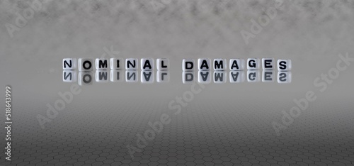 nominal damages word or concept represented by black and white letter cubes on a grey horizon background stretching to infinity photo