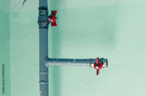 metal water pipes on the wall in a room with valves and fittings