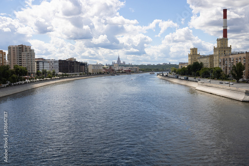 Embankments of the Moscow River with houses, chimneys of factories, Moscow State University in the distance. Cloudy weather.