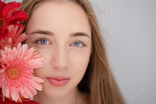Portrait of pretty young woman with pink and red chrysanthemum flowers