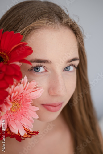 Portrait of pretty young woman with pink and red chrysanthemum flowers