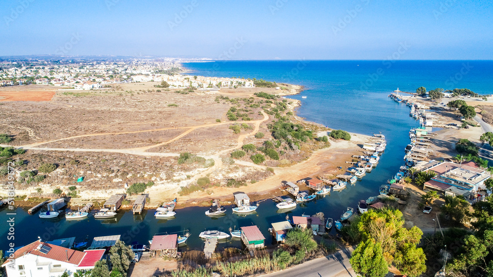 Aerial bird's eye view Liopetri river to sea (potamos Liopetriou), Famagusta, Cyprus.Fjord landmark tourist attraction fishing village with colourful boats moored on banks at Kokkinochoria, from above