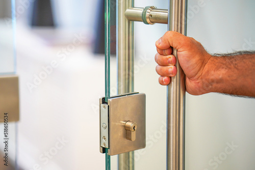 Male hand open the office glass door. Male hand open door knob. Man hand prepare to open the door to entering an office background