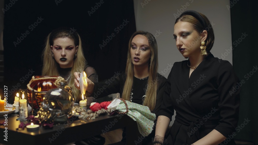 4K. Three female witches in a dark room conduct mystical sessions 4K. Three female witches in a dark room conduct mystical sessions