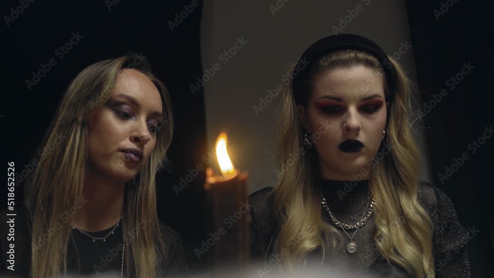 4K. Two female witches in a dark room reading tarot cards 4K. Two female witches in a dark room reading tarot cards