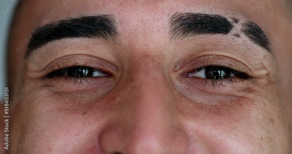 Close-up hispanic eyes closing and opening eyes in meditation. Smiling latino man Close-up hispanic eyes closing and opening eyes in meditation. Smiling latino man