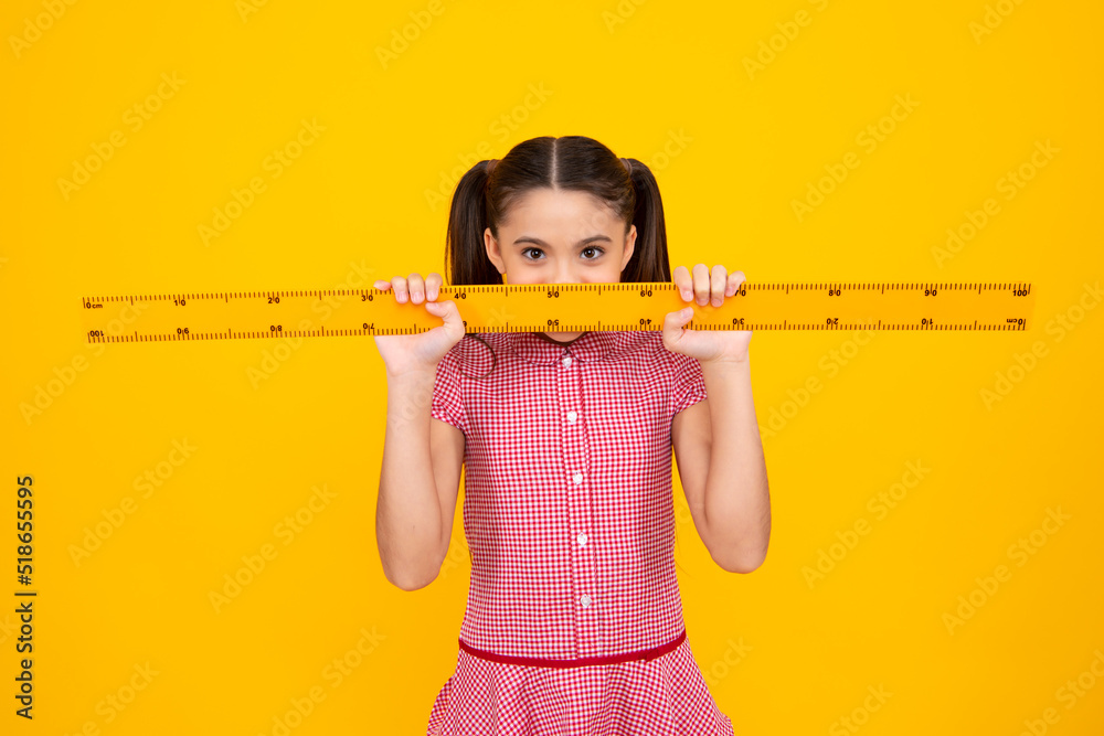 Back to school. School girl hold ruler measuring isolated on yellow background. Back to school. School girl hold ruler measuring isolated on yellow background.