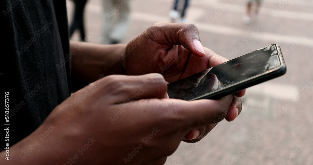 Black african person hands using smartphone browsing and touching screen