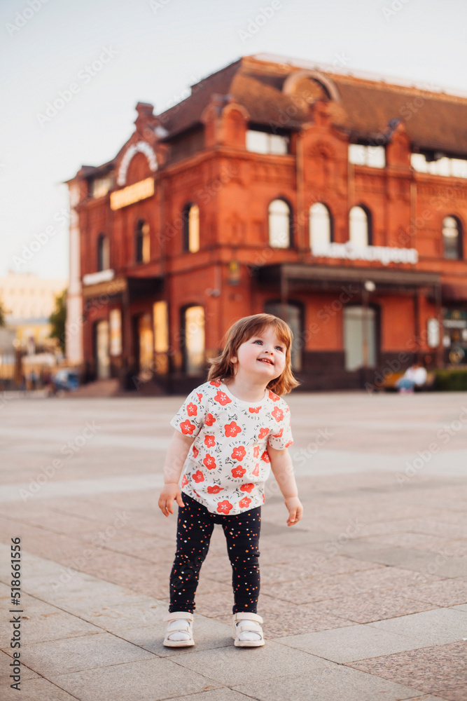 Naklejka premium little girl walking and playing on the street in summer