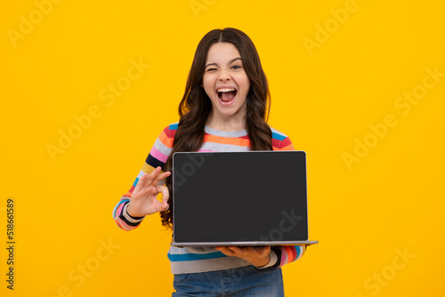 Amazed teenager. Student school girl with laptop on isolated studio background. Screen of laptop computer with copyspace mockup. Excited teen schoolgirl.