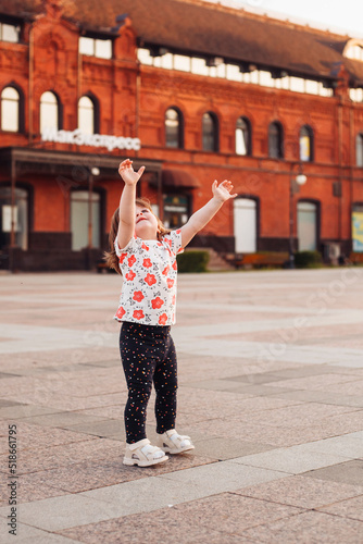 little girl walking and playing on the street in summer