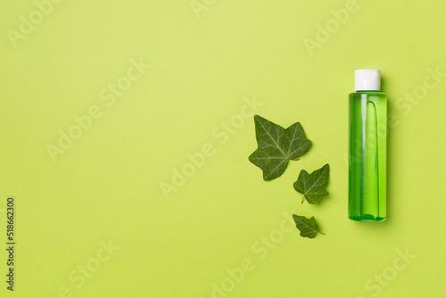 Cosmetic product with ivy extract on color background, top view