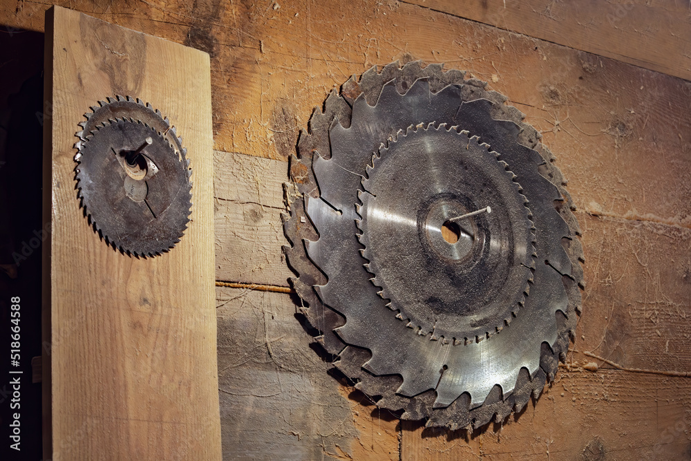 set of circular saw blades hangs on a wooden wall in the carpentry workshop. Circular saw. old rustic carpentry workshop. set of circular saw blades hangs on a wooden wall in the carpentry workshop. Circular saw. old rustic carpentry workshop.