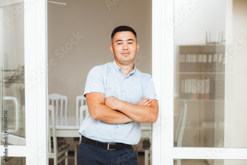 A young Asian businessman with his arms crossed on his chest in the office. portrait of a business man