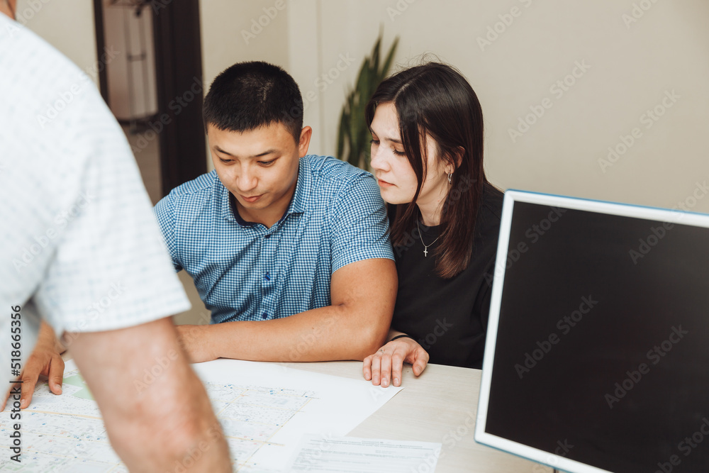 A happy couple signs a contract together in the office. a man and a woman buy an apartment and sign a contract. A happy couple signs a contract together in the office. a man and a woman buy an apartment and sign a contract.