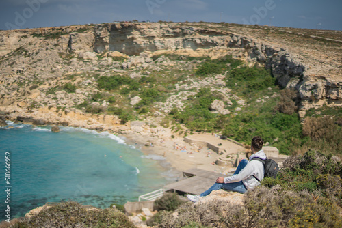 person is sitting on the cliff, top view, Paradise bay, Malta © Nikita