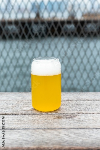 Canvas Print Vertical shot of a light lager beer in a glass on a pier