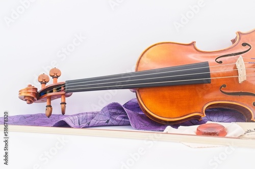 violin with bow, rosin and violin silk bag on a white desk photo