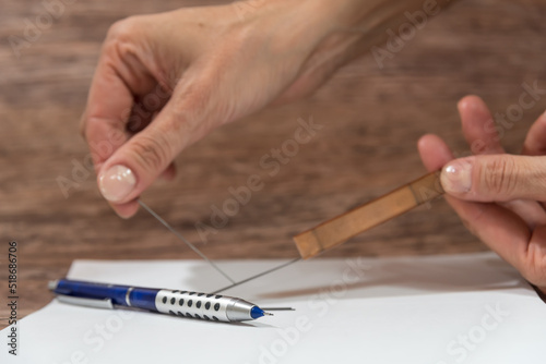 hands pulling graphite mines to place on a mechanical pencil