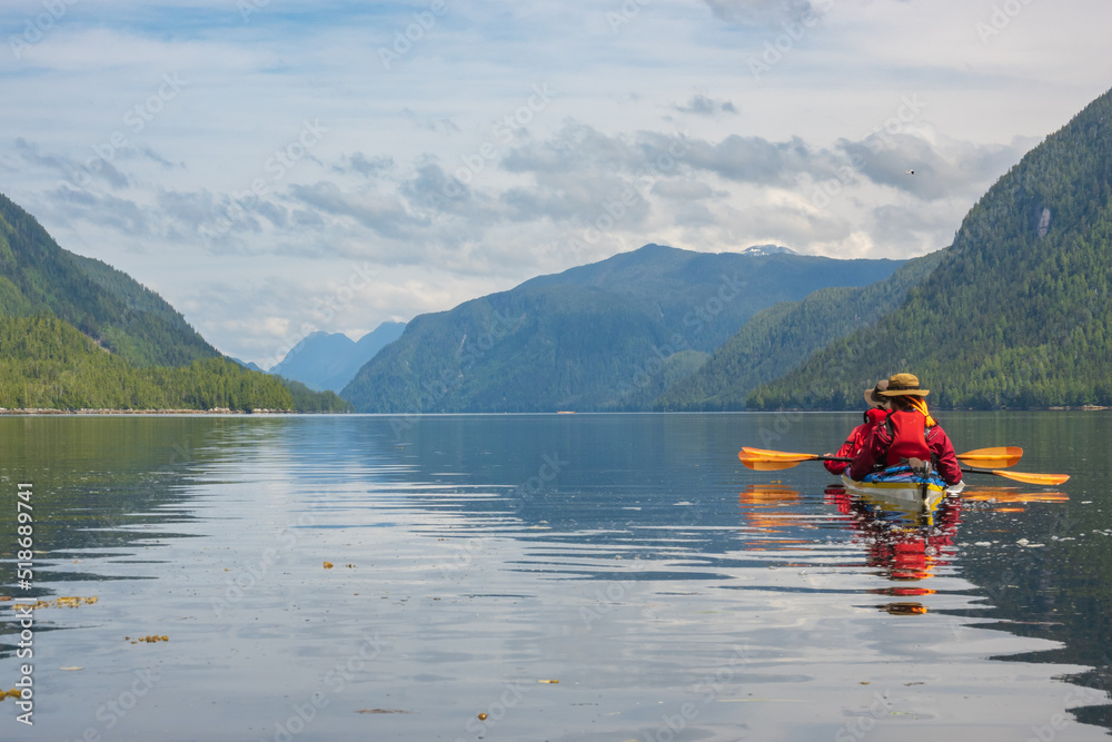 Se kayakers in a tandem look down a passage in Hieltsuk Territory on the Central Coast of British Columbia..  Room for text.