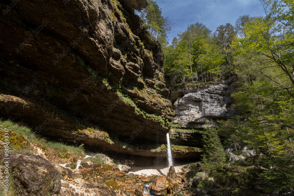 Pericnik waterfall with water falling  down a mountain, seen from below, with a blue sky in summer. Slap Pericnik falls are a waterfall of Slovenia, in Mojstrana, in the triglav national park.....