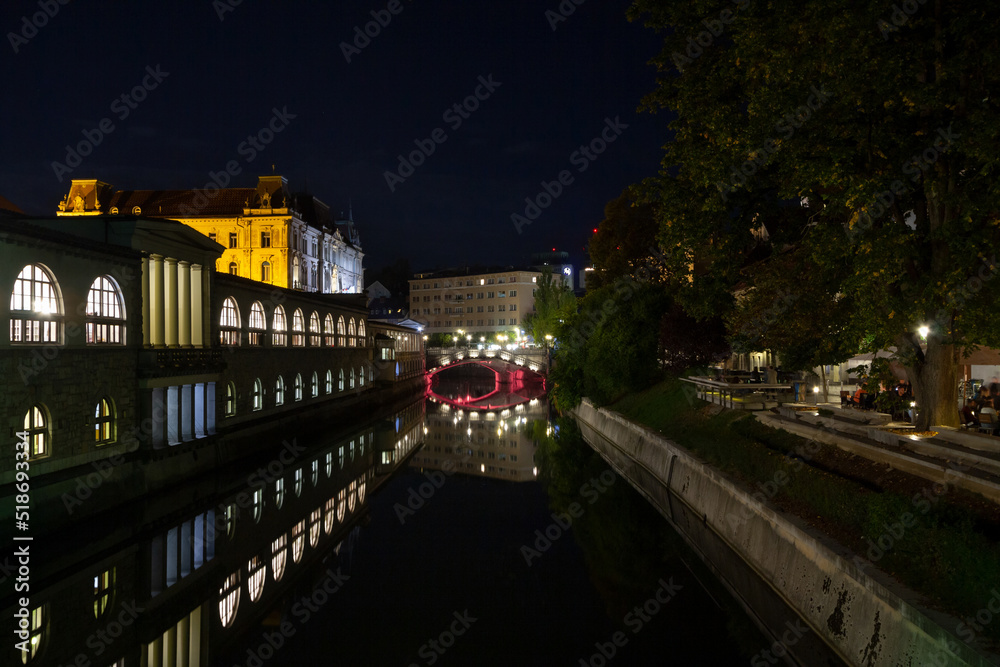Panorama of Ljubljanica river with the Tromostovje (triple most) rbidge in Ljubljana, capital city of Slovenia, taken during a summer night. this bridge is one of the main symbols of the city