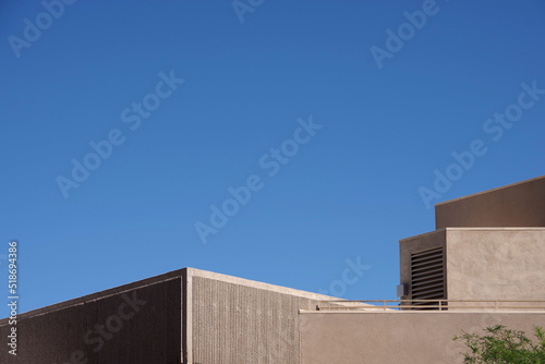Partial view of a desert architecture style building with blue sky above
