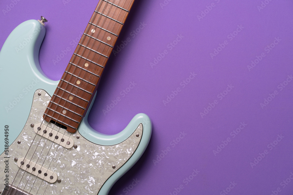 Obraz premium Electric guitar on purple table background, close up music concept
