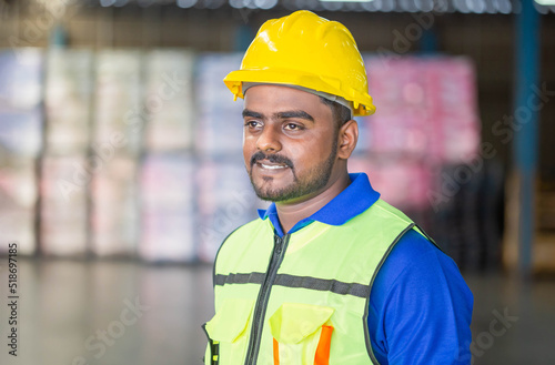 Portrait of Male worker wearing hardhat and safety vest standing in the warehouse, Young warehouse worker working in factory warehouse storag © JU.STOCKER