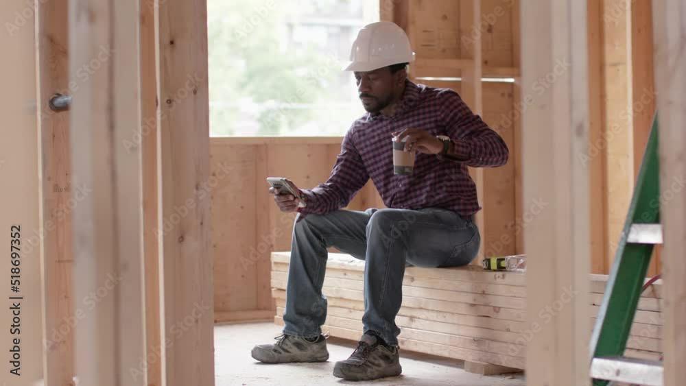 Break time! Contractor takes a break while he sips on his coffee and scrolls through his social media. Break time! Contractor takes a break while he sips on his coffee and scrolls through his social media.
