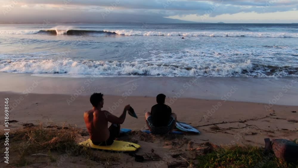 two male bodyboarders stretching and getting ready to surf big waves during sunrise two male bodyboarders stretching and getting ready to surf big waves during sunrise
