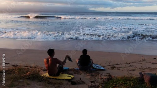 two male bodyboarders stretching and getting ready to surf big waves during sunrise photo