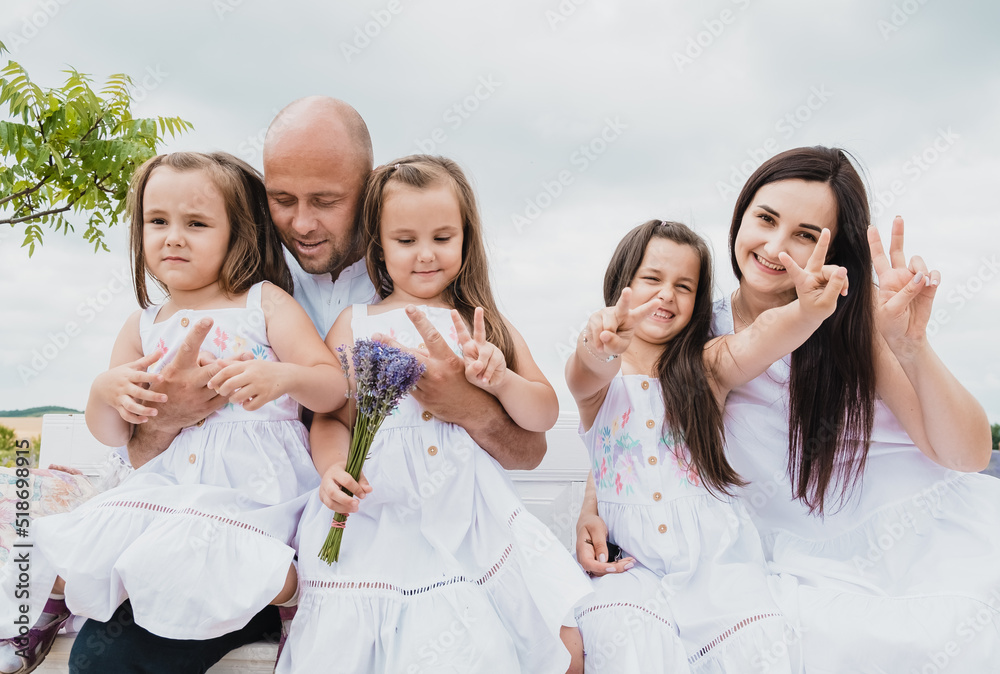 Happy cheerful family on vacation. Mom, and three children are playing, hugging.Family parent's children togetherness holiday concept.

