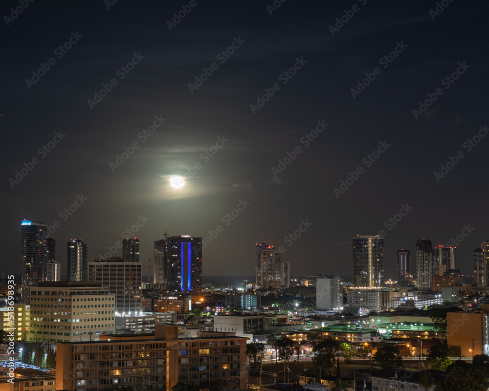 Fototapeta premium Moon Over a City at Night.
