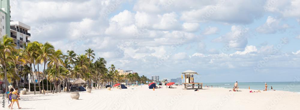 Panoramic landscape of a beach with unrecognizable people during a sunny day Panoramic landscape of a beach with unrecognizable people during a sunny day