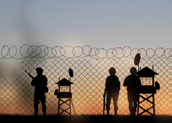 Silhouettes of border guards at post outdoors in evening