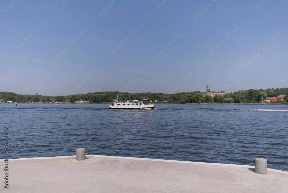 Panorama pier view over the bay Saltsjön, an old passenger steam boat passing on the way to the archipelago a sunny summer day in Stockholm