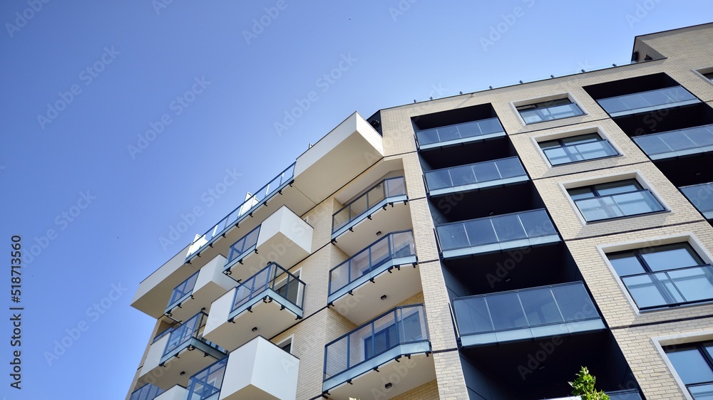 Exterior of new apartment buildings on a blue cloudy sky background. No people. Real estate business concept. Exterior of new apartment buildings on a blue cloudy sky background. No people. Real estate business concept.