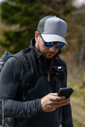Fototapeta Naklejka Na Ścianę i Meble -  Mann Outdoor mit Sonnenbrille und Smartphone