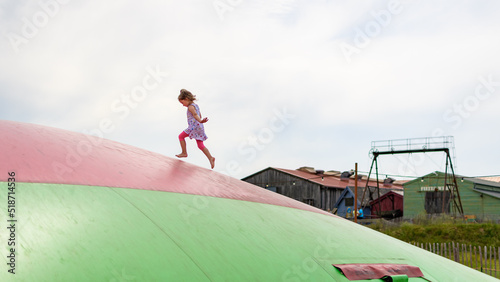 Kind rennt auf Hüpfkissen  photo