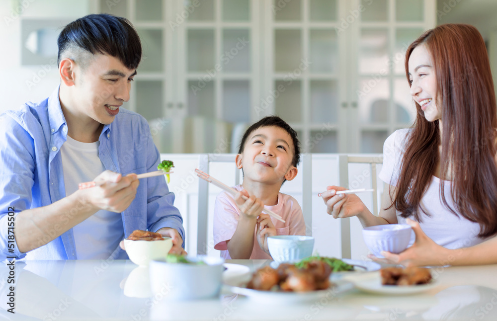 little boy enjoy eating food with father and mother. Happy Asian family having dinner at home little boy enjoy eating food with father and mother. Happy Asian family having dinner at home