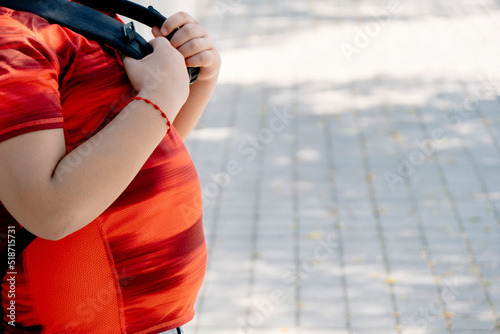 Childhood obesity concept. Boy with school bag with big belly.