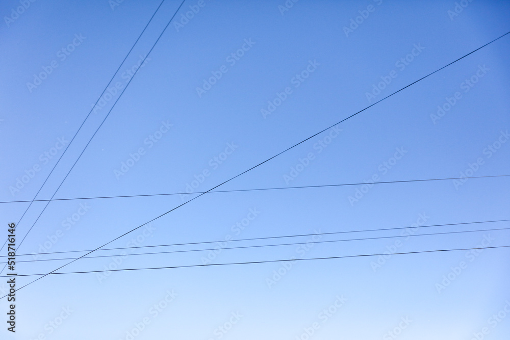 Electric wires against the blue sky. Background Electric wires against the blue sky. Background