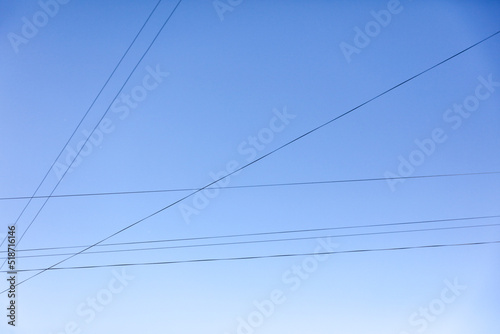 Electric wires against the blue sky. Background