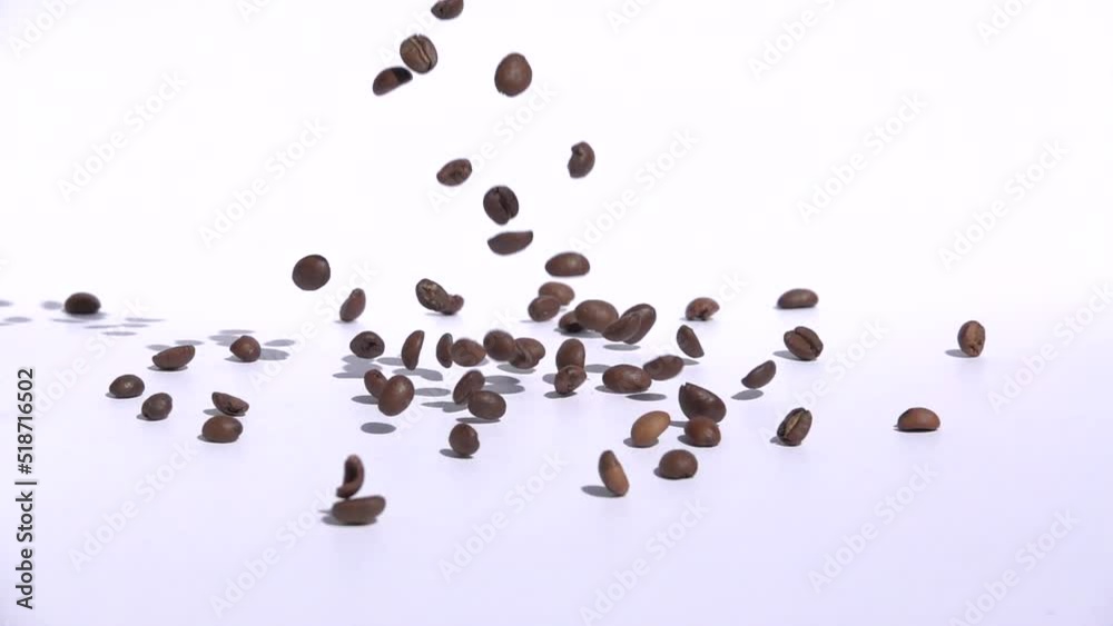 Heap of roasted coffee beans isolated on white background, in slowmotion Heap of roasted coffee beans isolated on white background, in slowmotion