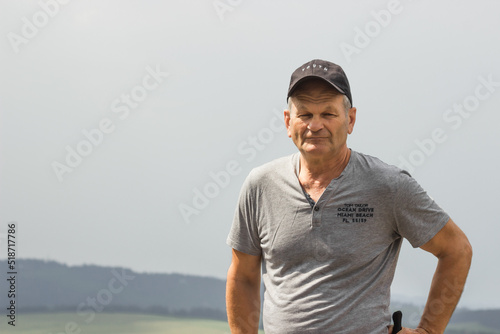 Portrait of smiling caucasian senior man cap in gray t-shirt with black baseball. Isolated on the white background.