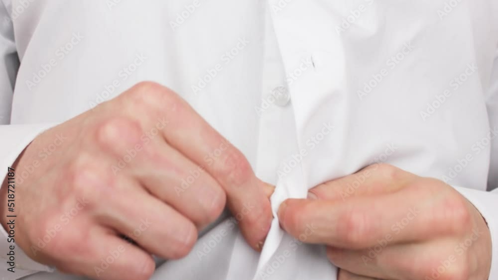 A man undoes the buttons on a white shirt.Take off the shirt.Men's button down shirt.Classic office shirt. A man undoes the buttons on a white shirt.Take off the shirt.Men's button down shirt.Classic office shirt.