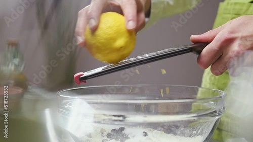 Chef grates lemon zest with a grater.
