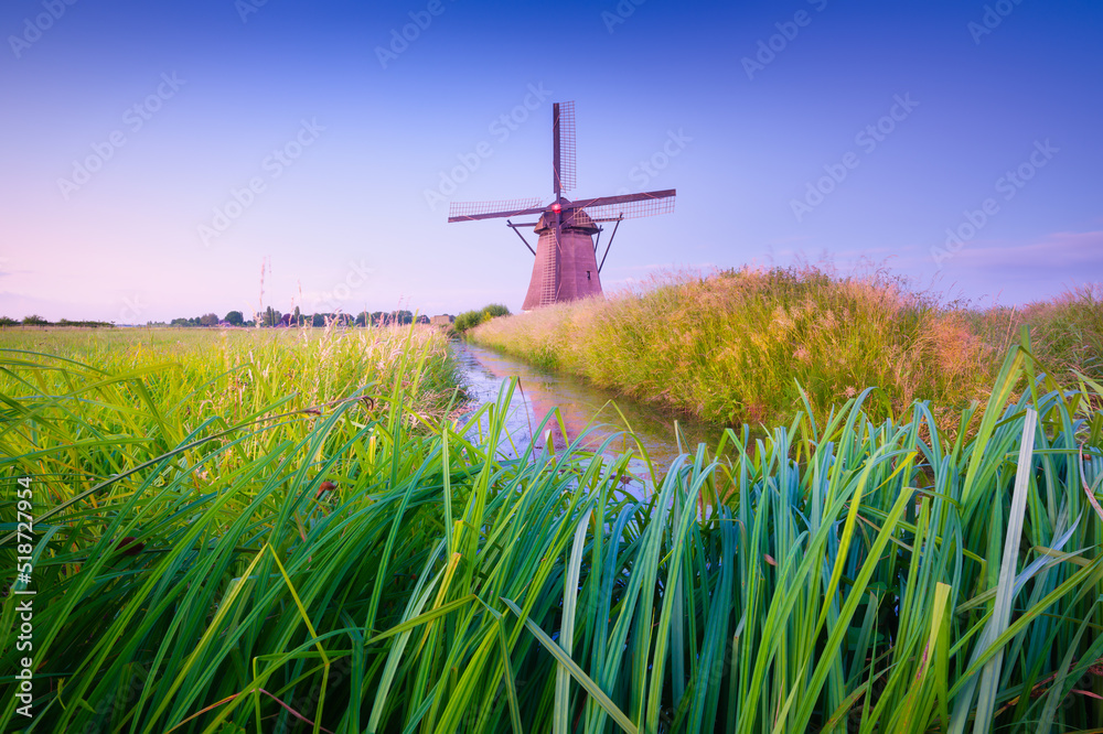 Windmills in the Netherlands. Historic buildings. Agriculture. Summer landscape during sunset. Bright sky and windmill. Photography for design. Windmills in the Netherlands. Historic buildings. Agriculture. Summer landscape during sunset. Bright sky and windmill. Photography for design.